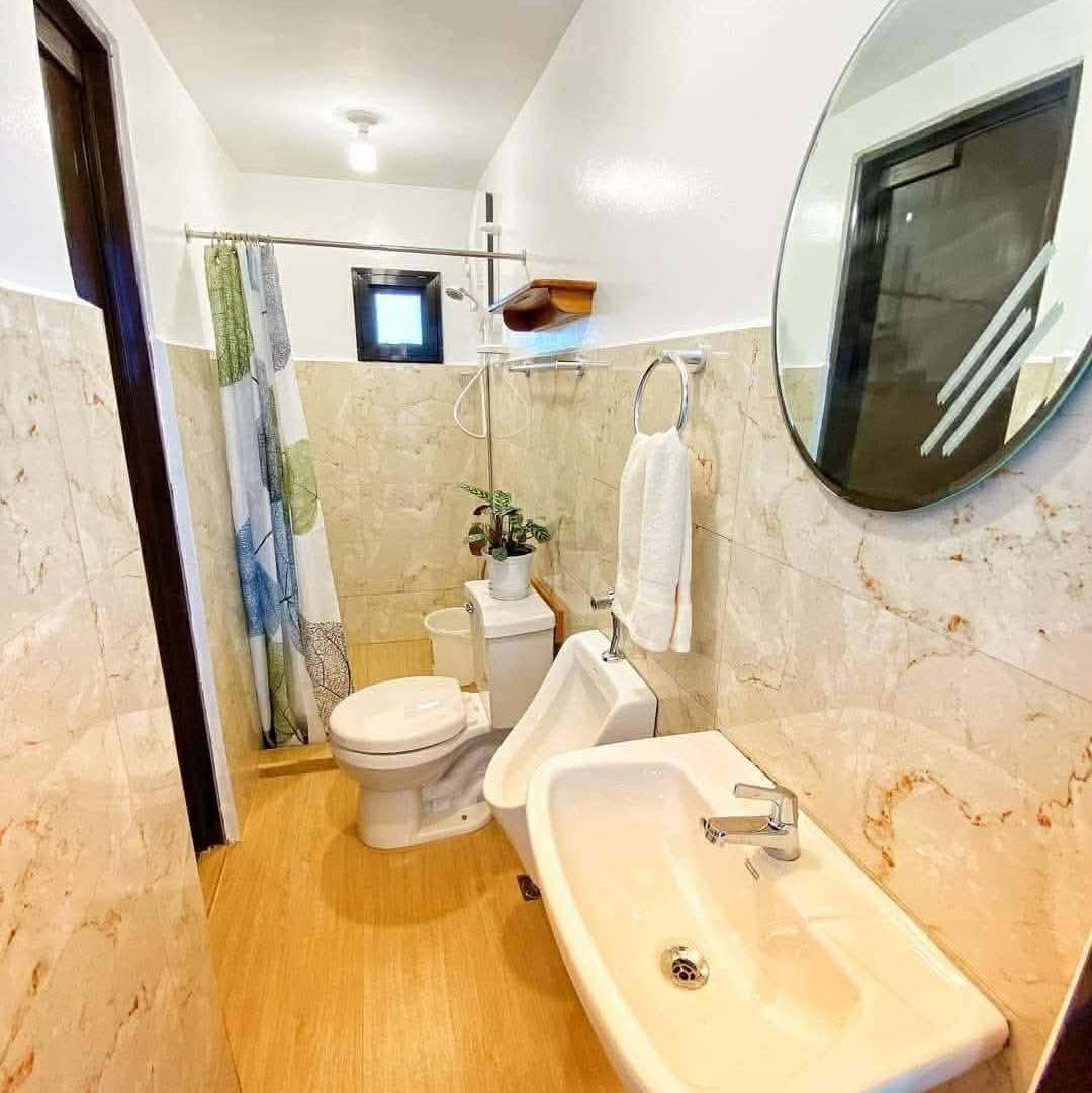 Clean tiled bathroom with shower, sink, and mirror