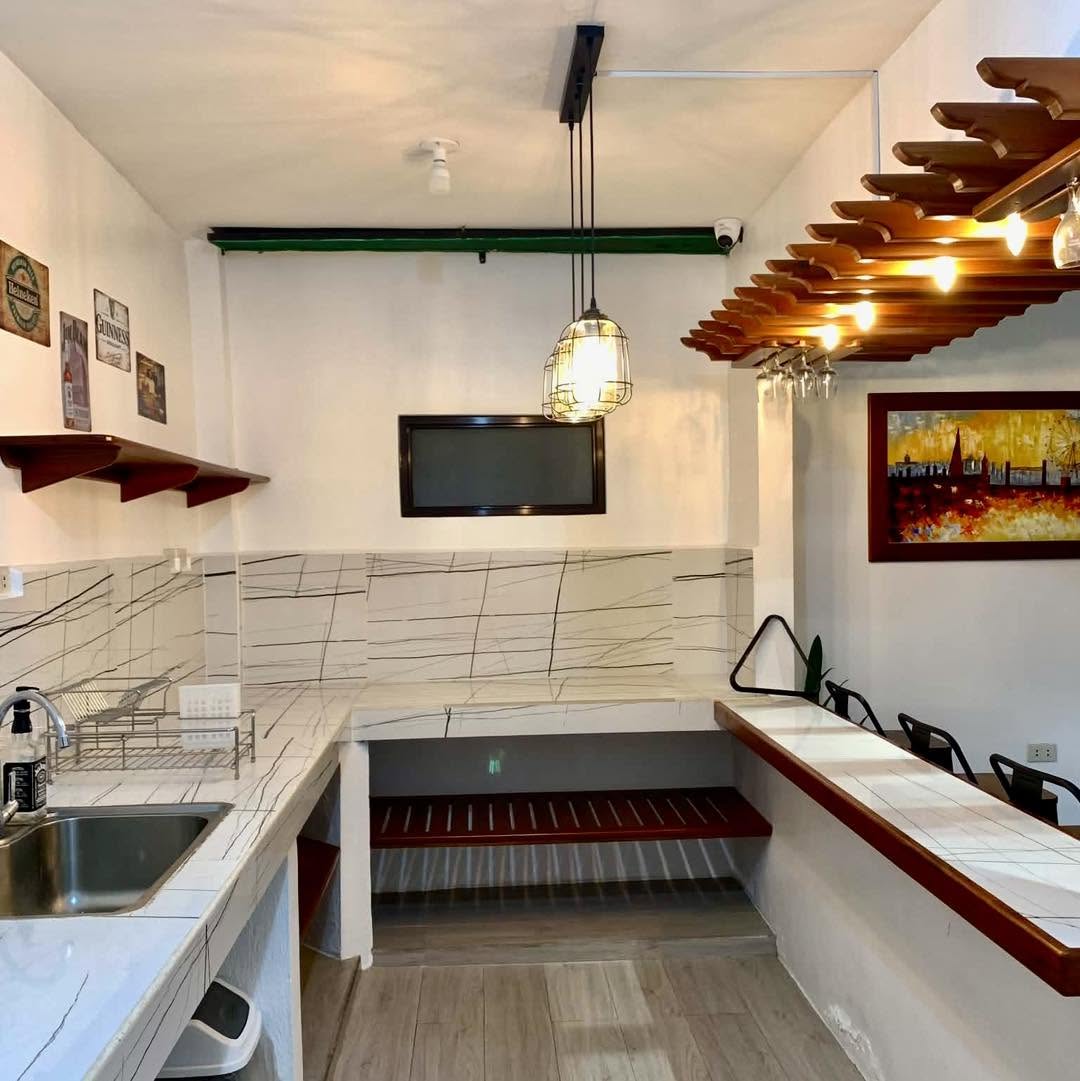 Equipped resort kitchen and dining counter with warm pendant lights