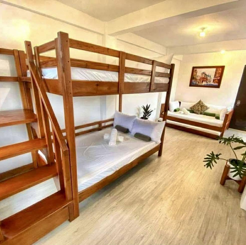 Spacious group bedroom with wooden bunk bed and day bed